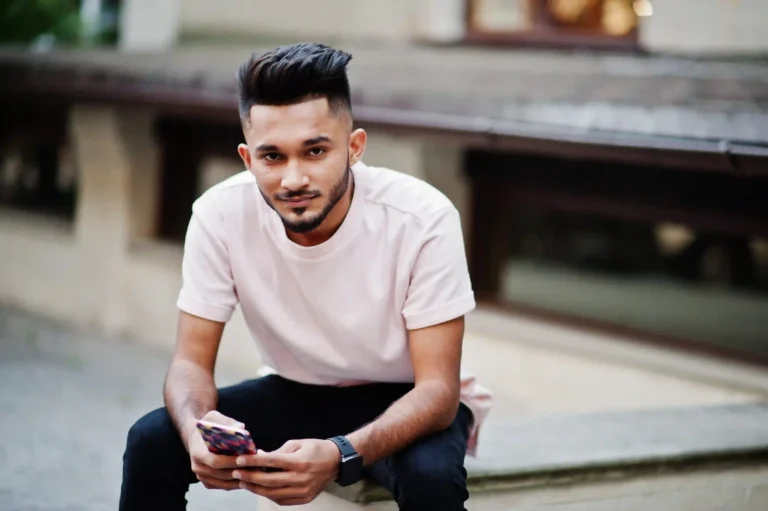 stylish-indian-beard-man-pink-tshirt-india-model-sitting-with-mobile-phone-hands-outdoor-streets-city